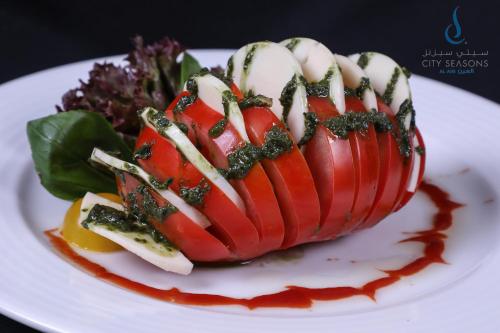 a plate of food with a red and white dessert at All Seasons Hotel Al Ain - Previously City Seasons in Al Ain
