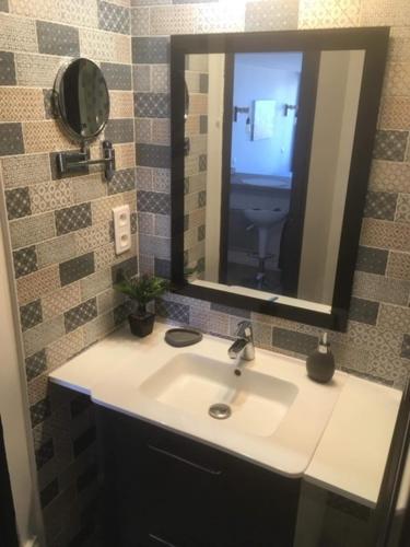 une salle de bain avec un lavabo et un miroir dans l'établissement Les Marinas Port Deauville, à Deauville