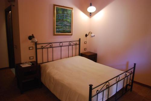 a bedroom with a bed and a picture on the wall at Agriturismo Cascina Madonnina in Pregnana Milanese