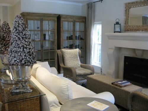 a living room with a white couch and a fireplace at Maison d'Ail Guest House in Franschhoek