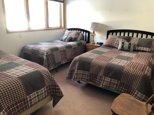 a bedroom with two beds and two windows at Anglers Retreat in Crump