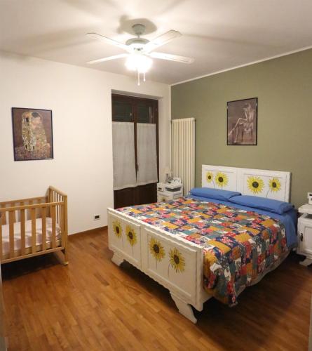 a bedroom with a bed and a crib in it at Villa con piscina e intera struttura a uso esclusivo casa del moré in La Morra