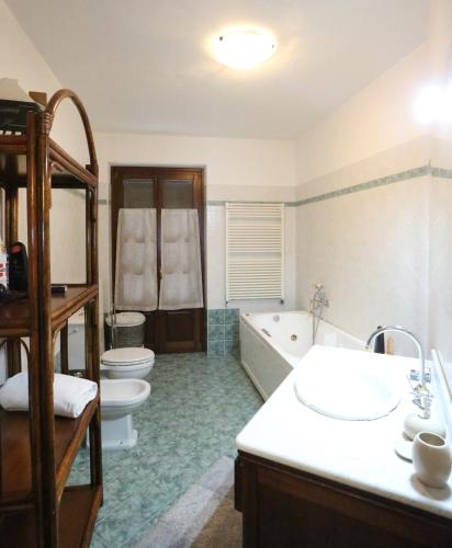 a bathroom with a tub and a toilet and a sink at Villa con piscina e intera struttura a uso esclusivo casa del moré in La Morra