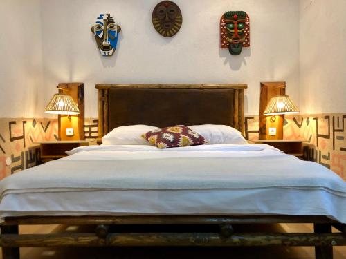 Guest House Adriatica by Pinch في باكوشتاني: غرفة نوم بسرير كبير بها مصباحين وساعات