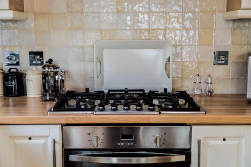 a stove top oven in a kitchen with a microwave at Bonnie Banks Lodge Ardlui in Ardlui