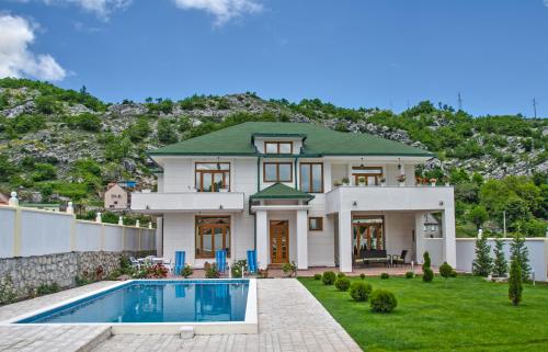 a large house with a swimming pool in the yard at Villa Ramonte in Cetinje