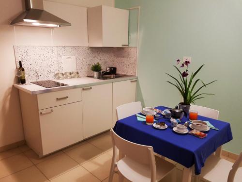 a table with a blue table cloth on it in a kitchen at Parco Della Rocca in Punta Braccetto