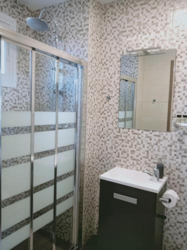 a bathroom with a shower and a sink and a mirror at El Cielo Azul in Alora
