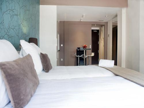 a bedroom with a large bed with white sheets and pillows at Barcelona Fifteen central Aparthotel in Barcelona