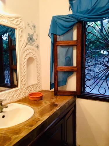 a bathroom with a sink and a window at Boutique Hotel Nyumbani Tembo in Watamu