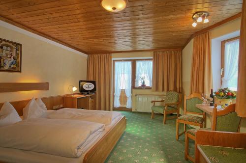 シェーナウ・アム・ケーニッヒスゼーにあるHotel Bergheimatのベッド、テーブル、椅子が備わるホテルルームです。
