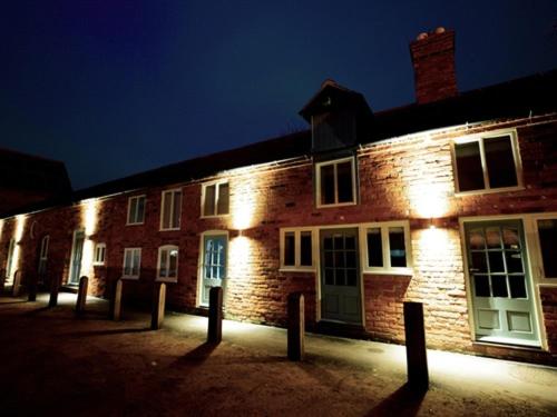 a brick building at night with lights on it at THE COACHING BARNS in Shrewsbury