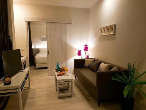 a living room with a couch and a table at TREX Buriram Boutique Hotel in Buriram