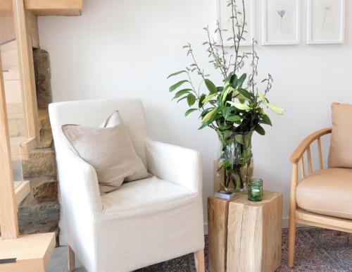 a living room with a chair and a vase of flowers at Lancaster Barn in Lancaster