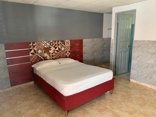 una camera con letto con testiera rossa di RESIDENCIAL AGUADULCE a Aguadulce