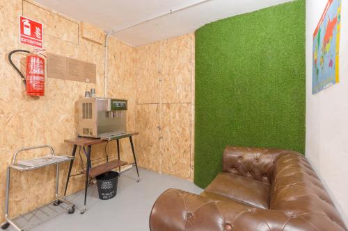 un sofá de cuero en una habitación con paredes verdes en Tomate Rooms, en Alicante