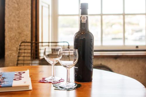 ポルトにあるPorto Premium River View Iのワイン1本とワイングラス2杯(テーブル上)