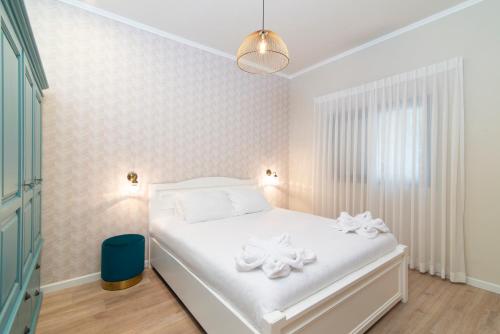 a bedroom with a bed with white sheets and flowers on it at Yehuda Central Park by TLV2RENT in Tel Aviv