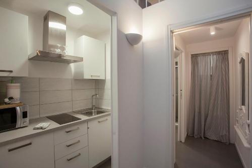 a white kitchen with a sink and a microwave at La Casa Bianca in Florence