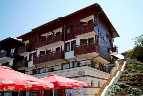 a building with red umbrellas in front of it at Family Hotel Saint Nikola and Free parking in Nesebar
