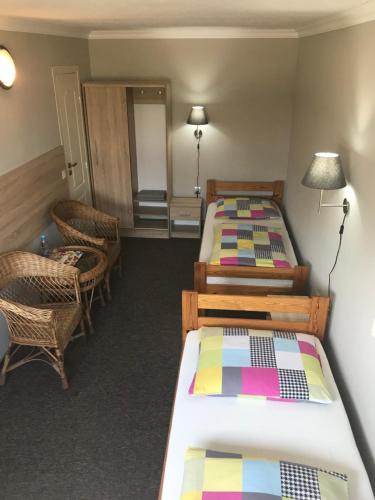 a room with two beds and a table and chairs at Restauracja Zajazd Trefl in Czarlin