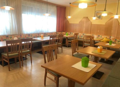 a dining room with wooden tables and chairs at Gasthaus-Pension zum Löwen in Asten