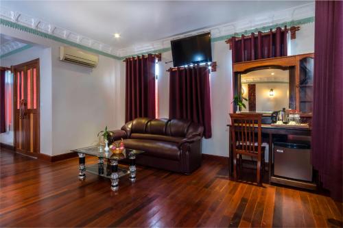 a living room with a leather couch and a bar at Hello Cambodia Boutique in Siem Reap