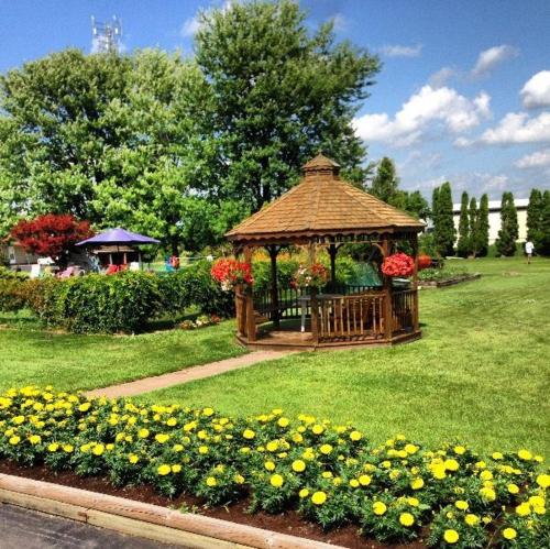 a gazebo in the middle of a park with flowers at Majers Motel in Stratford