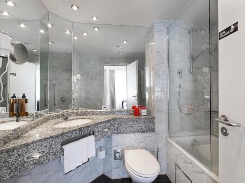 a bathroom with a toilet and a sink and a shower at DORMERO Hotel Dessau-Roßlau in Dessau