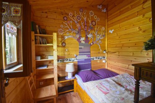 um quarto com uma cama num chalé de madeira em Chalet à fleur de rêve em Maroilles