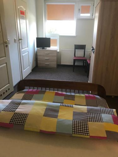 a bedroom with a bed with a colorful quilt on it at Restauracja Zajazd Trefl in Czarlin