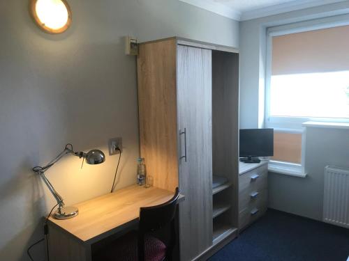 een kamer met een bureau met een lamp en een raam bij Restauracja Zajazd Trefl in Czarlin