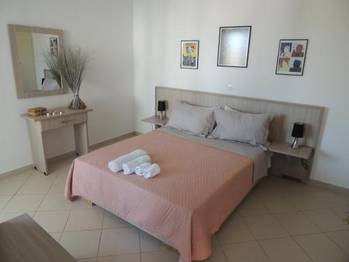 a bedroom with a bed with two towels on it at levante studios Αndros in Ménites