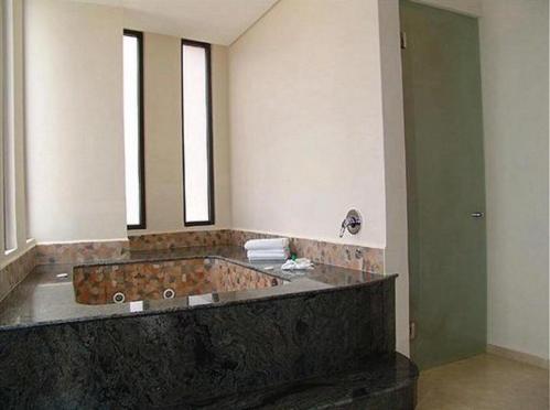 a bathroom with a large stone tub in a room at Holiday Inn Veracruz-Boca Del Rio, an IHG Hotel in Veracruz