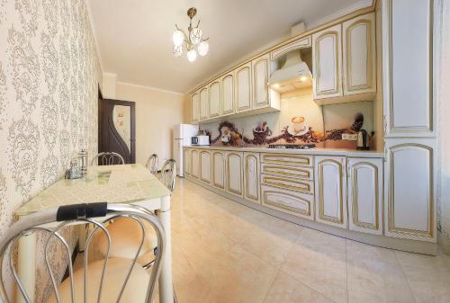 a large kitchen with white cabinets and a table at Luxury Apartament 2 in Truskavets
