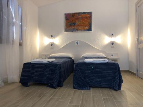 two beds in a room with a painting on the wall at B&B Villamarina42 in Flumini di Quartu