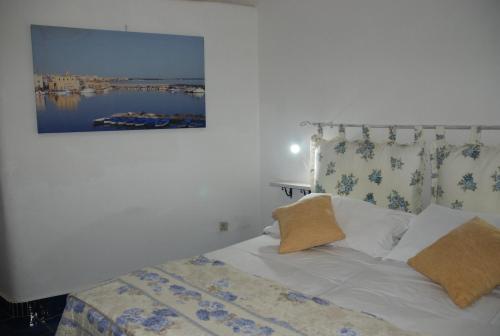 a bedroom with a bed with a picture on the wall at B&B Dimora San Vincenzo in Gallipoli