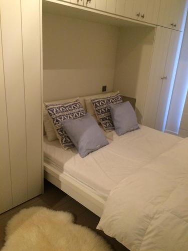a bedroom with a bed with pillows and a mirror at Residentie TYL - Leopoldlaan 122 in Knokke-Heist