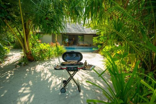 a barbecue grill sitting in the middle of a garden at The Residence Maldives at Dhigurah in Gaafu Alifu Atoll
