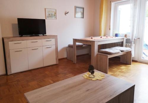 ein Wohnzimmer mit einem Tisch und einem TV in der Unterkunft Ferienwohnung Neuber in Bad Kissingen