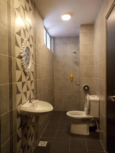 a bathroom with a toilet and a sink at ICOLOR HOME & STAY CH 8 in Tanah Rata