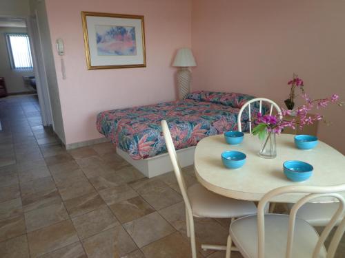 Habitación con mesa, cama, mesa y sillas. en Isle of Palms Motel, en Wildwood