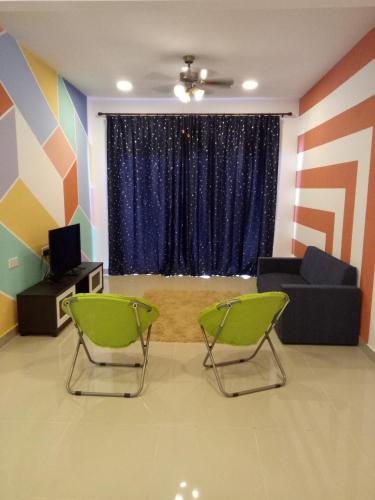 a living room with two chairs and a couch at ICOLOR HOME & STAY CH 8 in Tanah Rata