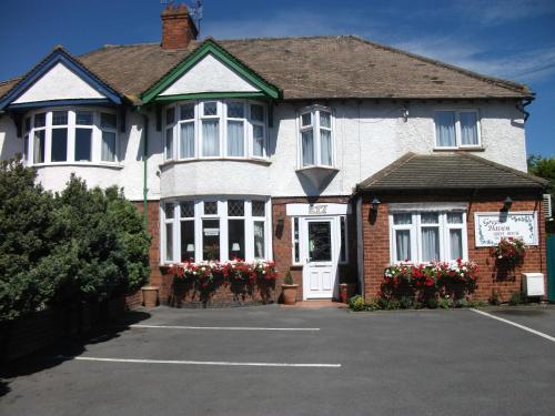 a large white house with flowers in front of it at Green Haven Guest House in Stratford-upon-Avon