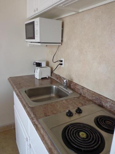 a kitchen with a sink and a stove top oven at Beach Terrace Motor Inn in Wildwood