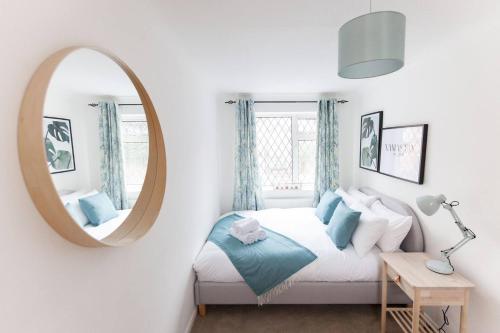 a bedroom with a bed and a round mirror at Moda Stays - Oxford House in Birmingham