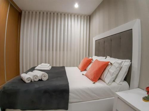 
a bed with a white comforter and pillows at OPORTO House AL in Maia
