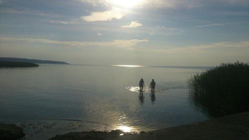 two people standing in the water on a beach at Pokoje Gościnne Ewa Nowicka in Frombork