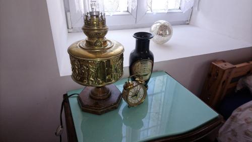 - une table en verre avec une horloge et une bouteille dans l'établissement Chambre centre Pleyber-Christ, à Pleyber-Christ