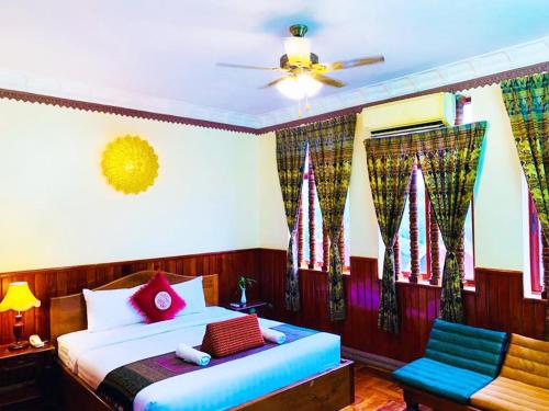 1 dormitorio con 1 cama y 1 silla en Okay 1 Villa, en Siem Reap